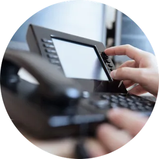 Mano marcando en un teléfono IP de escritorio